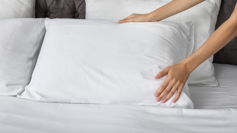 Someone plumping a pillow