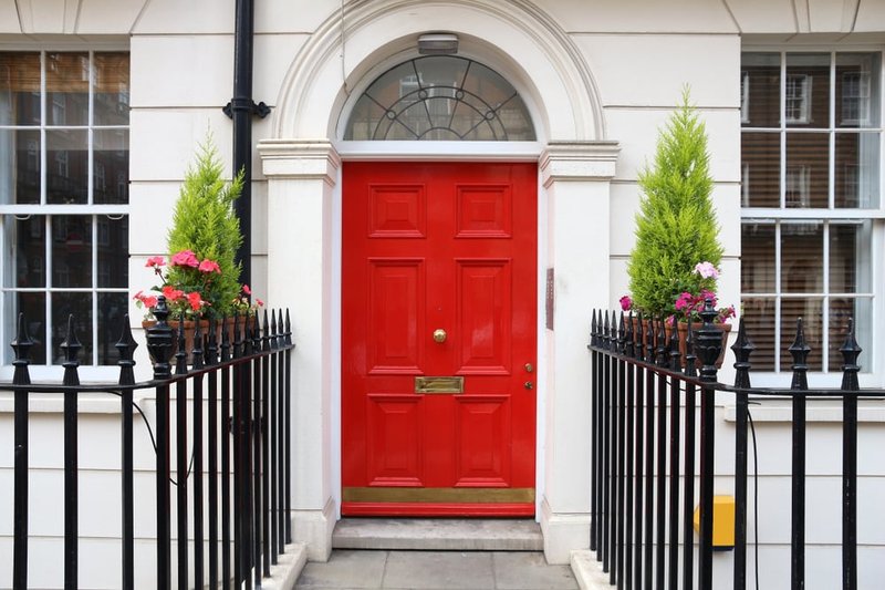 Red front door and iron fence